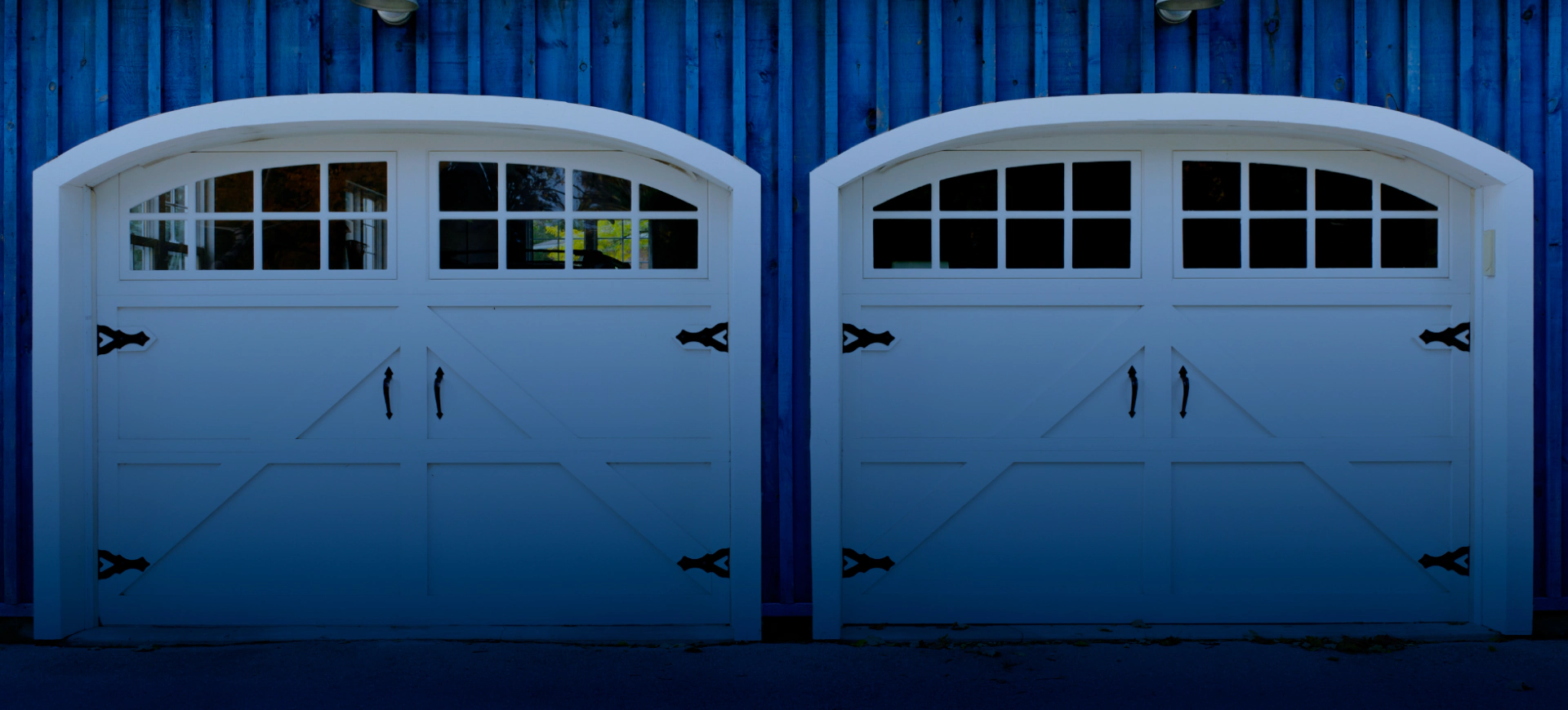 two white garage doors and blue house